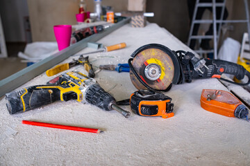 Dusty construction tools lie on a white table covered in dust. Construction.Repairs
