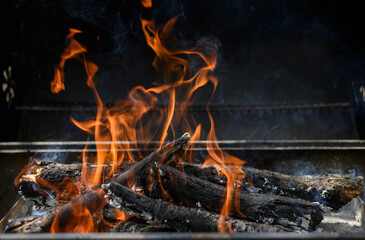 Fototapeta premium A hot fire in barbeque on a black background. Summer bbq concept