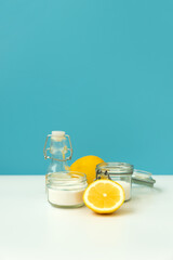 Set of eco cleaning products. Eco sponges, lemons, apple vinegar, citric acid and soda on blue background.