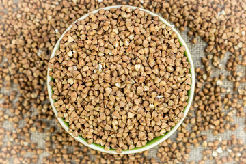 buckwheat (raw, dry) is poured into a round plate, defocused buckwheat is scattered around
