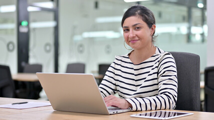 Fototapeta na wymiar Cheerful Indian Woman with Laptop saying Yes by Head Shake 