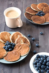 Banana and oatmeal pancakes with blueberries for breakfast. A mug of coffee on the table. Gluten free. Sugar-free. Proper nutrition.
