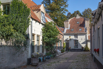 Small street with old small and authentic houses and flowers in the center of Elburg in the Netherlands.	