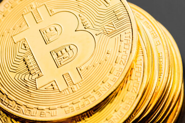 Macro view of gold color shiny coins with bitcoin symbol