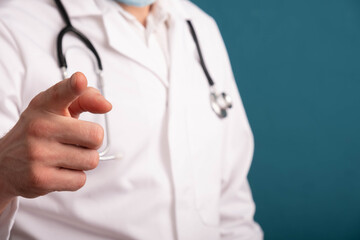 doctor in a white coat, with a stethoscope on his shoulders, shows a finger