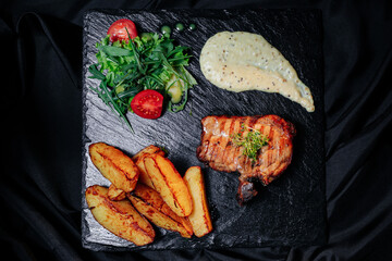 grilled steak with salad and fries