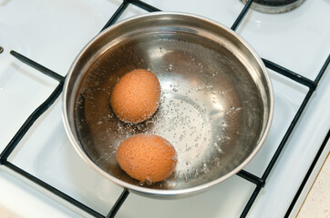 Closeup of three eggs boiling in pot of hot water