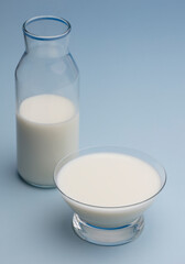 glass of cereal milk, with glass bottle, blue background