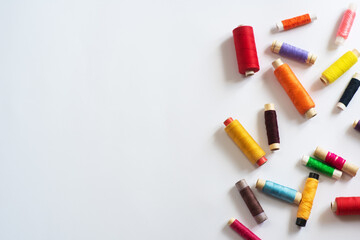 Frame with multi-colored reels with threads on a white background. Top View