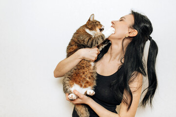 Obraz premium beautiful smiling brunette girl and her cat over white background