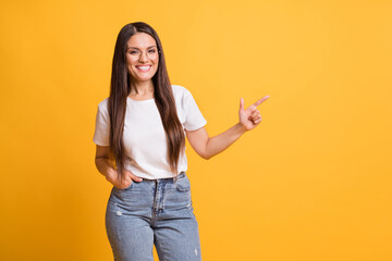 Photo of positive brunette mature woman point index finger empty space feedback isolated on yellow...