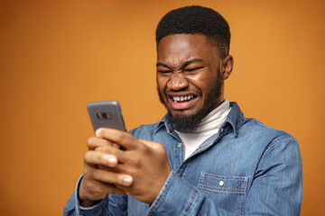 Angry frustrated young african american man recieved message with bad news on his phone