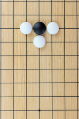 Training simple position of black and white stones on the playing field (gohan) of traditional Chinese strategy game go