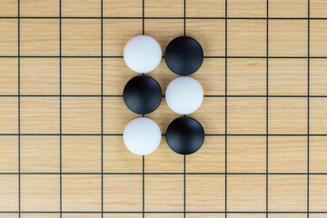 Black and white stones on the playing field (gohan) of Chinese game go