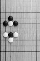 Training simple position of black and white stones on the playing field (gohan) of traditional Chinese strategy game go