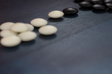 Black and white stones of traditional Chinese game go on blue table