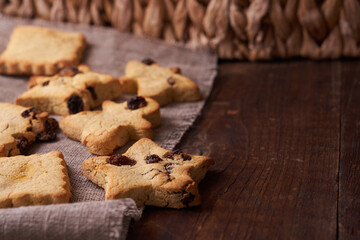 Healthy homemade gluten-free, lactose-free cookies of various shapes without sugar with raisins and chocolate on a dark brown wooden background