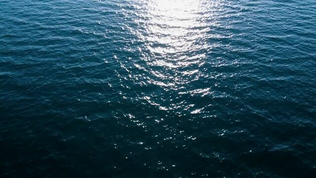 Aerial drone view of sea waves. Sun reflection on water surface. Disturbed ocean surface.  