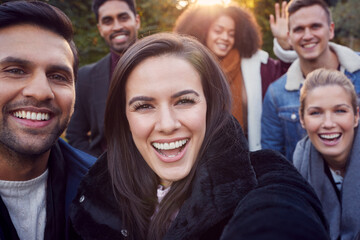 Portrait Of Multi Cultural Group Of Friends Enjoying Outdoor Walk In Fall Or Winter Countryside