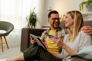 Happy Caucasian couple doing online shopping with credit card.