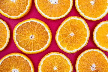 Yellow juicy orange on a red background. Background on the theme of fruits, citrus fruits.