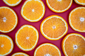 Yellow juicy orange on a red background. Background on the theme of fruits, citrus fruits.