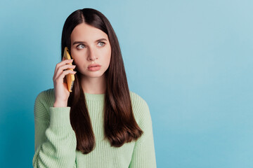 Young sad girl talk phone isolated over blue background