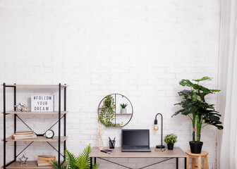 Workspace with table, chair, rack and plants in office