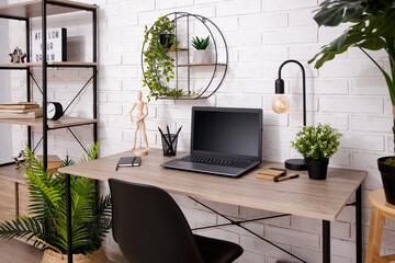 Modern workplace with laptop on wooden table