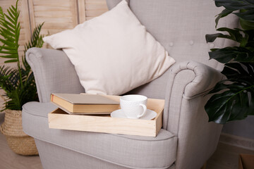 Reading concept - book with cup on armchair