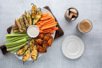 Top down view of an appetizer platter surrounded by plates and cola beverages ready for snacking.