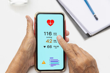 Senior woman checking blood pressure (hypertension) vai mobile phone