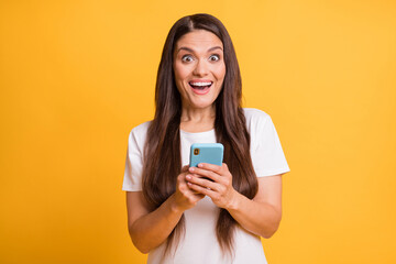 Naklejka premium Photo portrait of female blogger commenting browsing internet smiling happy isolated on vibrant yellow color background