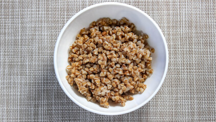 Boiled buckwheat plate close-up on the table. Diet dinner.