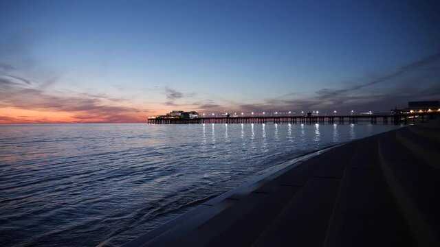4K: Blackpool North Pier, England, UK at dusk. A Wide shot with reflections in the sea. Stock Video Clip Footage