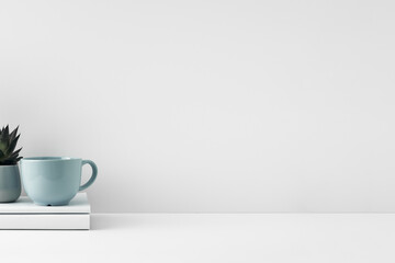 The mug stands on a stack of books on a white background. Natural and eco-friendly materials. Copy space, mock up.
