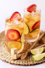 Glass of Tasty and Cold Ice Tea with Strawberry and Lime Healthy Diet and Summer Beverage Vertical