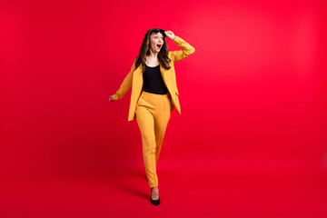 Full length body size view of attractive cheerful amazed stunned girl going touching specs isolated over bright red color background