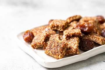 Coconut cookies with dates and carrots in a white bowl on a light background close-up. The concept of a healthy snack no sugar