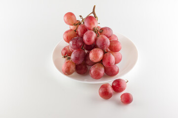 bunch of fresh grapes lies on a dinner plate