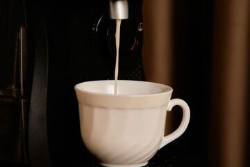 A cup of coffee is poured from the coffee machine.
