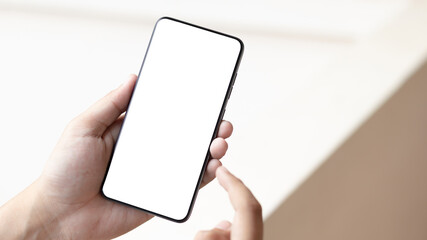 Hand holding and using smartphone with white blank on screen.