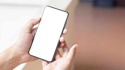 Hand holding and using smartphone with white blank on screen.