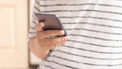 Hand holding and using smartphone.