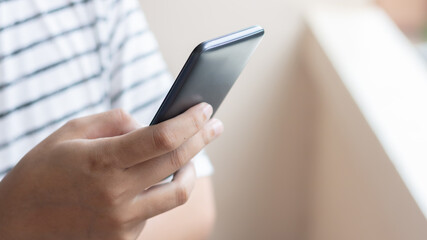 Hand holding and using smartphone.