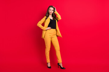 Photo of adorable shiny young woman wear yellow jacket arm waist hair smiling isolated red color background