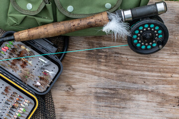 fly fishing equipment on a old wooden board background, negative space 