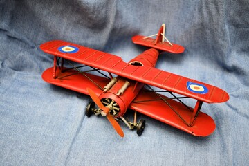 Old vintage toy red plane wings black chassis macro closeup still life blue background