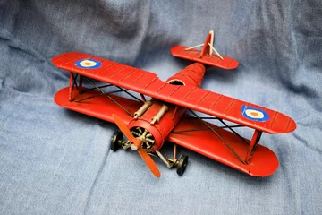 Wallpaper murals Old airplane Old vintage toy red plane wings black chassis macro closeup still life blue background