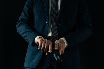 古いセミオートマチックピストルを構えるスーツの男性